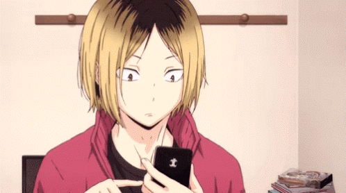 Kenma observando su celular y tecleando en el mismo.
